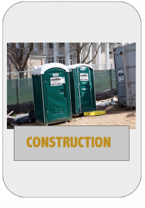 A couple of green portable toilets sitting next to each other.